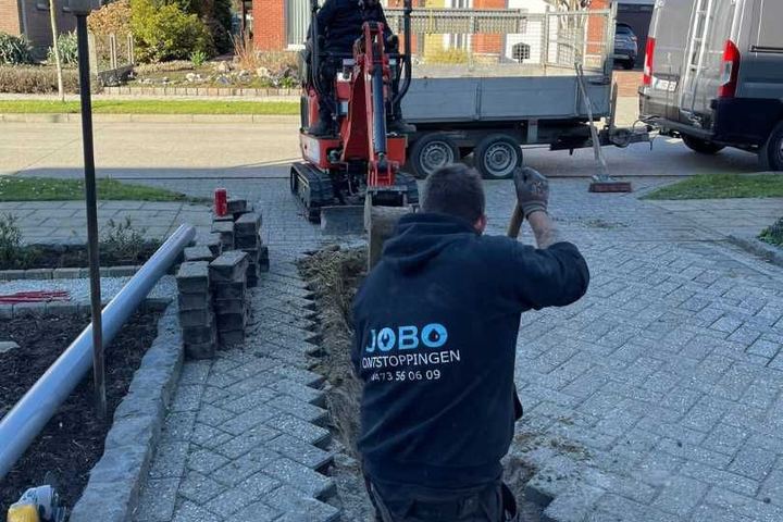 Rioleringswerken met minigraver bij een oprit